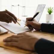 person signing settlement documents with lawyer