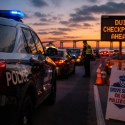 Maryland State Police officer conducting a Memorial Day weekend DUI checkpoint near the Chesapeake Bay Bridge at sunset on Maryland’s Eastern Shore.
