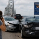 Traffic collision on Maryland’s Route 50 near the Chesapeake Bay Bridge involving an out-of-state vehicle, with damaged cars stopped on the roadway and a driver calling for assistance during heavy summer traffic.