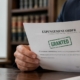 Person holding an approved expungement order in a Maryland law office, with legal books and scales of justice visible, symbolizing criminal record clearance and new employment opportunities.